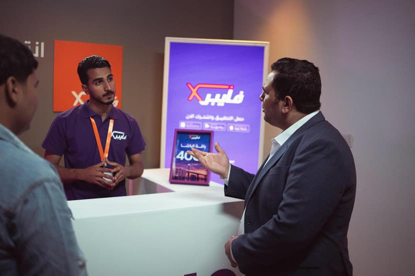 Two people discussing a product catalog at a trade show booth