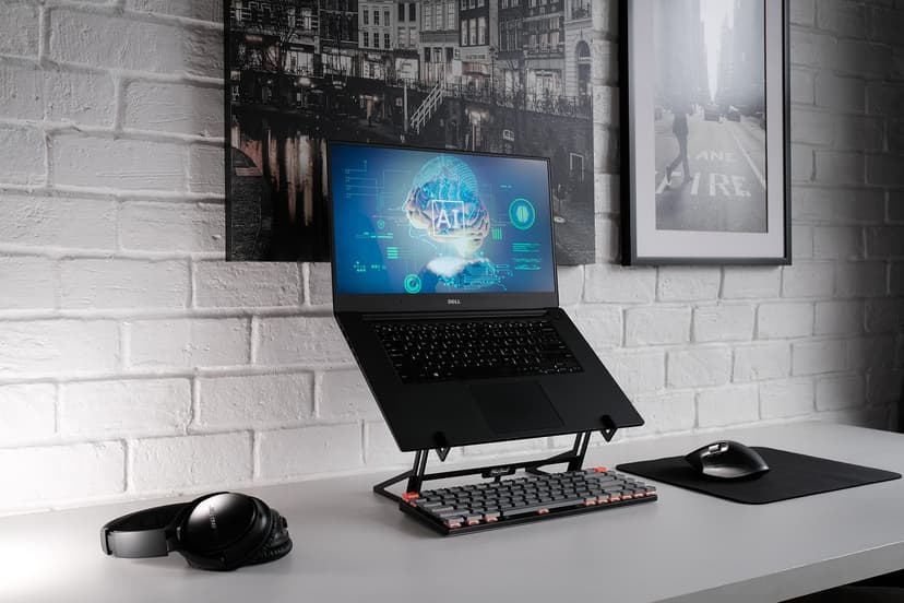 A desk with a laptop screen showing global AI governance monitoring and handwritten notes beside it