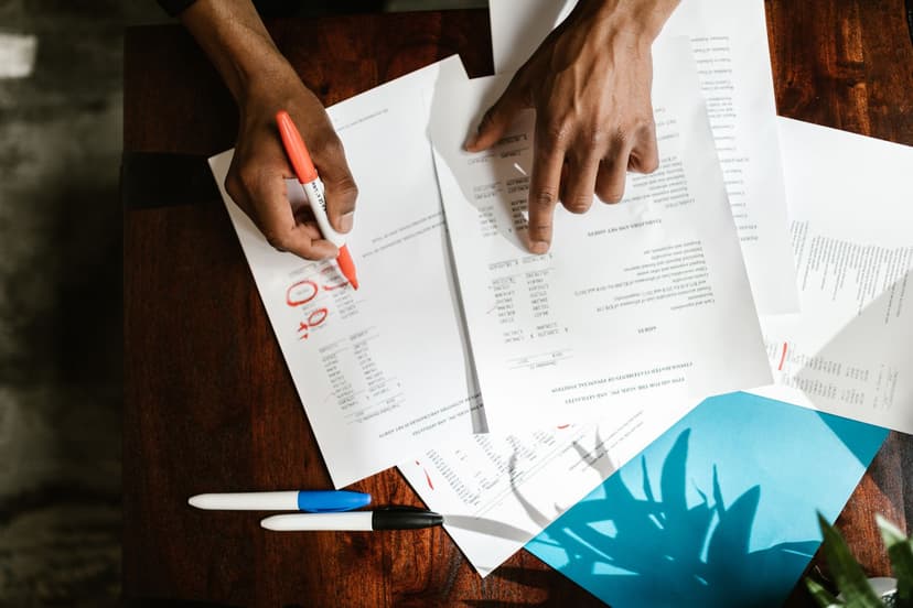Developer meletakkan tumpukan printout kode tebal di meja dan menggaris dengan stabilo